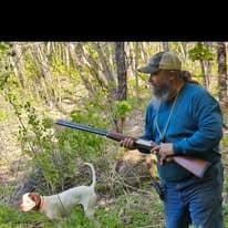 Hunter working with pointer in upland cover